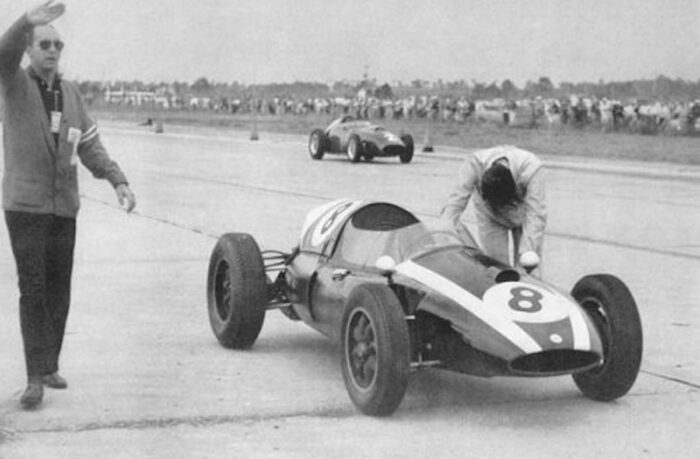 Jack Brabham empujando su auto a la línea de meta en Formula 1